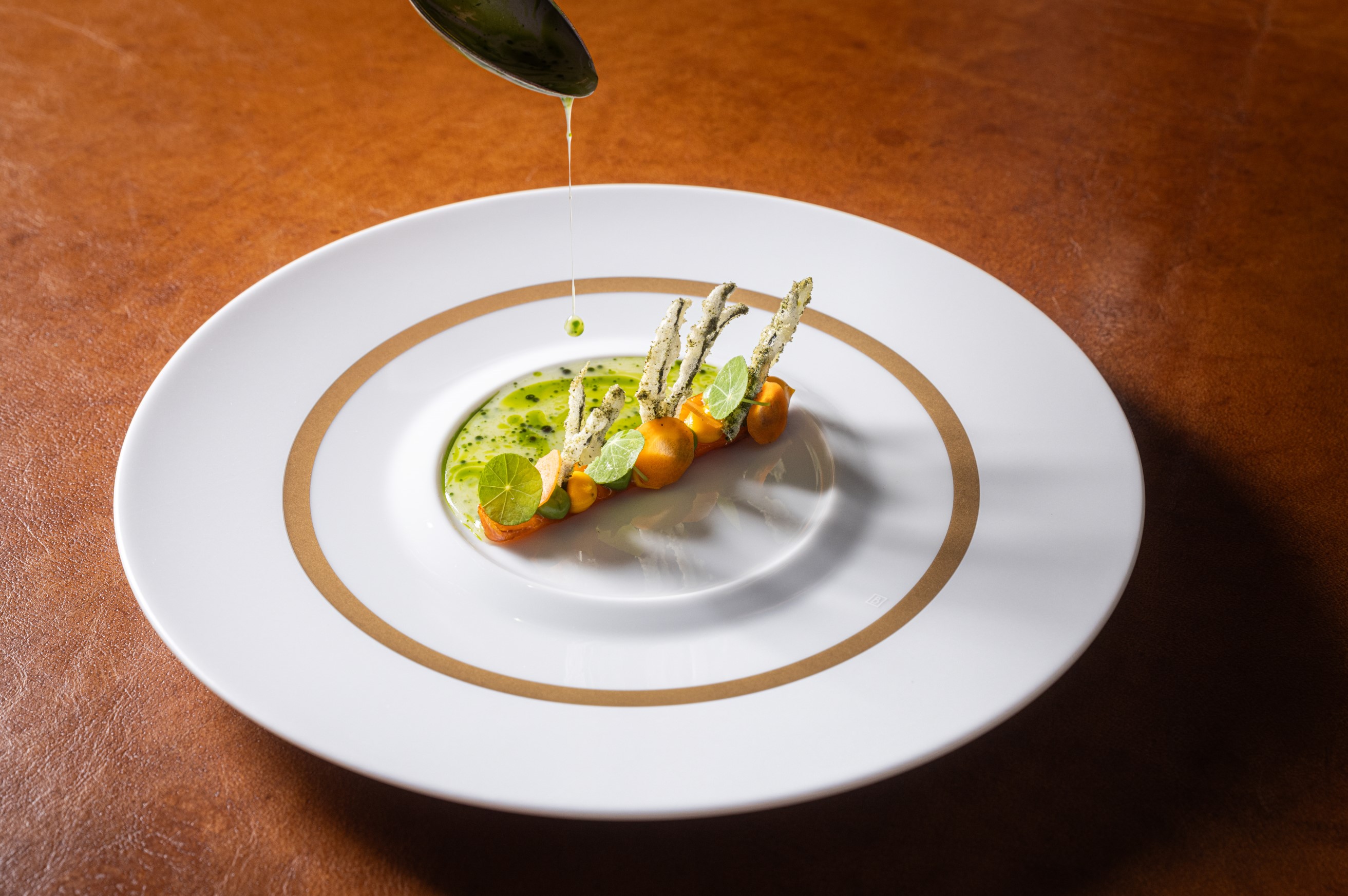 Bospeen, gepoft in de oven en geglaceerd in huisgemaakte miso. Daarop crème van wortel en crème van wakame met in tempura gebakken codium. Saus van gerookte koji-bouillon met groenekruidenolie.